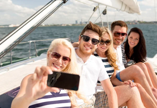 Uśmiechnięci przyjaciele siedzący na pokładzie jachtu — Zdjęcie stockowe
