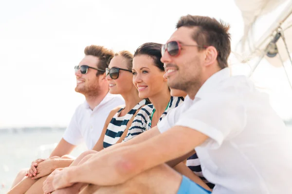 Усміхнені друзі сидять на яхтній палубі — стокове фото