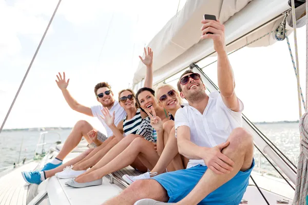 Amigos sonrientes sentados en la cubierta del yate — Foto de Stock