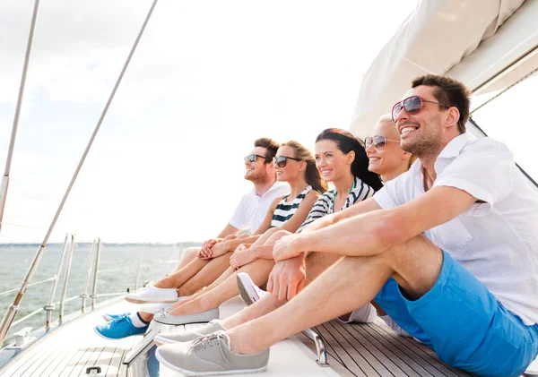 Amici sorridenti seduti sul ponte dello yacht — Foto Stock