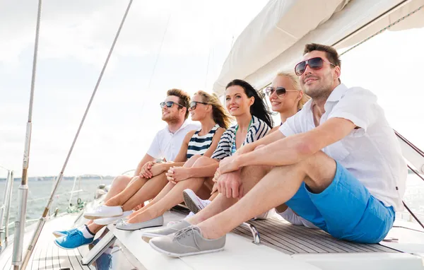 Smiling friends sitting on yacht deck — Stock Photo, Image