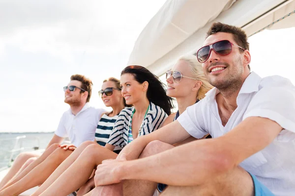 Amici sorridenti seduti sul ponte dello yacht — Foto Stock