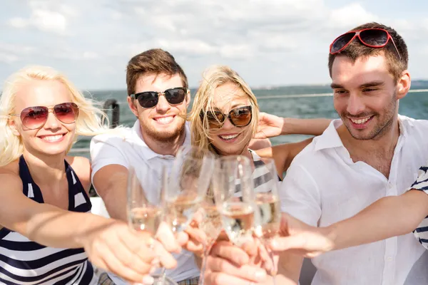 Улыбающиеся друзья с бокалами шампанского на яхте — стоковое фото