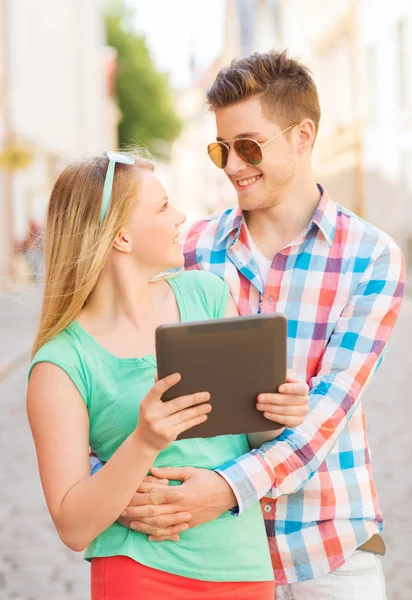 Lachende paar met de tablet pc in stad — Stockfoto