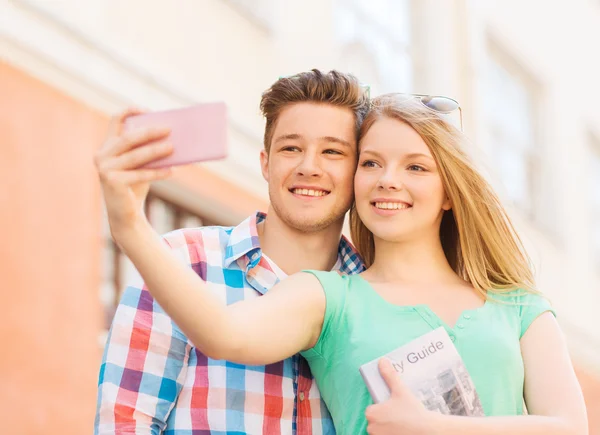 Uśmiechający się para z smartphone w mieście — Zdjęcie stockowe