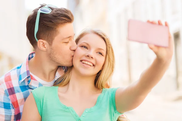 Pareja sonriente con smartphone en la ciudad —  Fotos de Stock