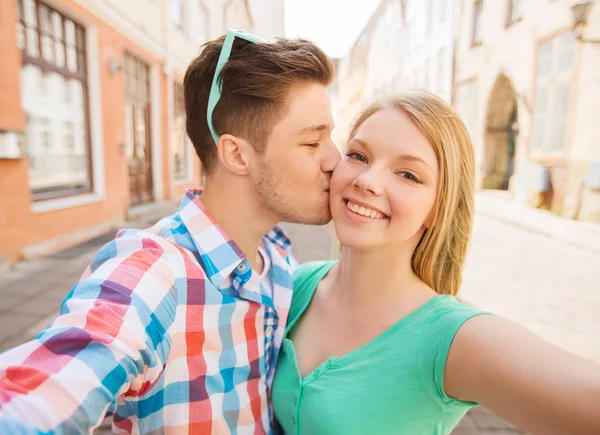Couple souriant avec smartphone en ville — Photo