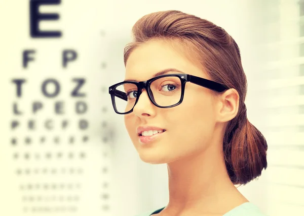 Woman in eyeglasses with eye chart — Stock Photo, Image