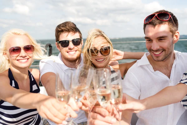 Amigos sorridentes com copos de champanhe no iate Fotografia De Stock