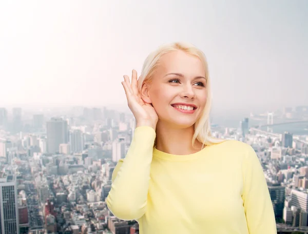 Souriant jeune femme à l'écoute des commérages — Photo