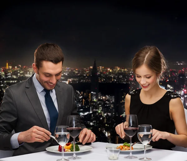 Uśmiechnięta para jedząca danie główne w restauracji — Zdjęcie stockowe