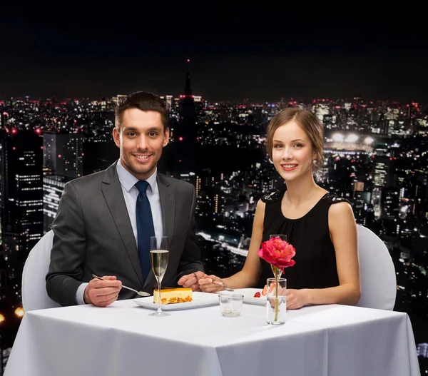 Smiling couple eating dessert at restaurant — Stock Photo, Image