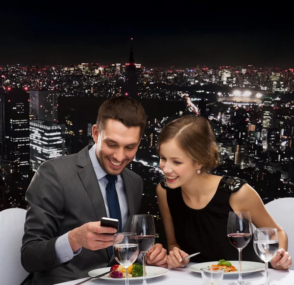 Sonriente pareja comiendo plato principal en restaurante —  Fotos de Stock