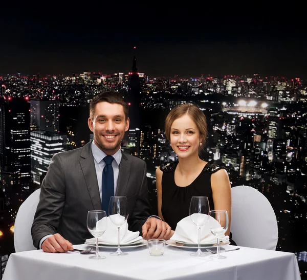Smiling couple holding hands at restaurant — Stock Photo, Image