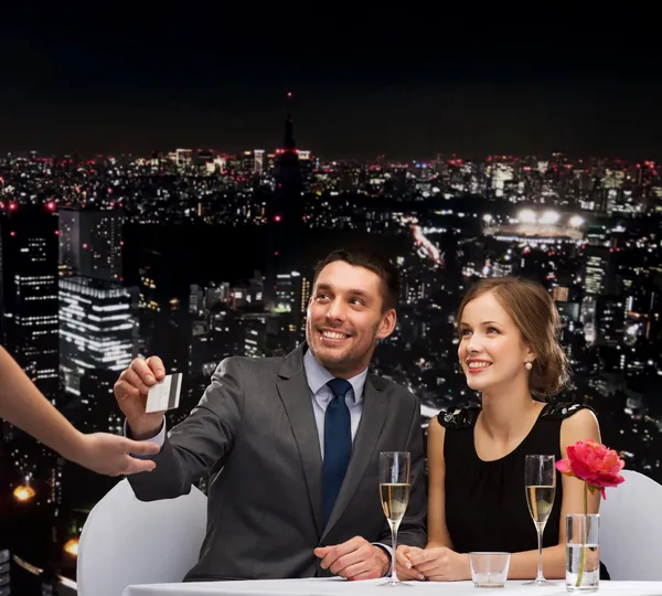 Casal sorrindo pagar o jantar com cartão de crédito — Fotografia de Stock