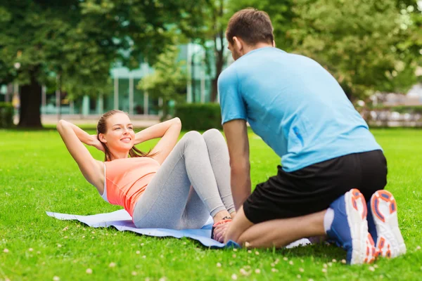 Leende kvinna gör övningar på matta utomhus — Stockfoto