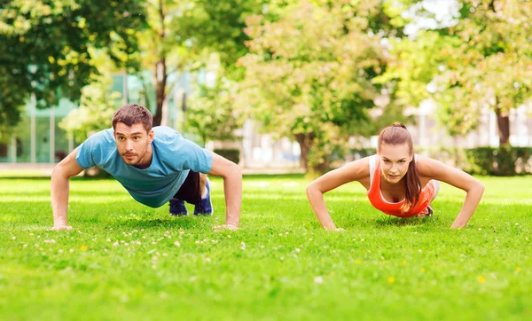 Couple doing push-ups outdoors — Stock Photo, Image