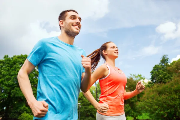 Smiling couple running outdoors Stock Image