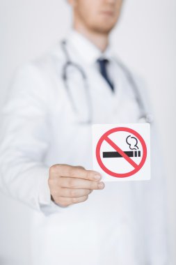 male doctor holding no smoking sign clipart