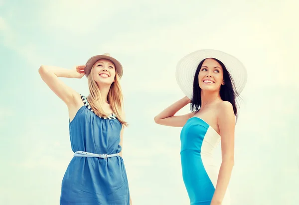 Chicas en vestidos con sombreros en la playa — Foto de Stock