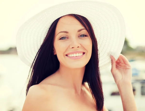 Mädchen mit Hut steht am Strand — Stockfoto