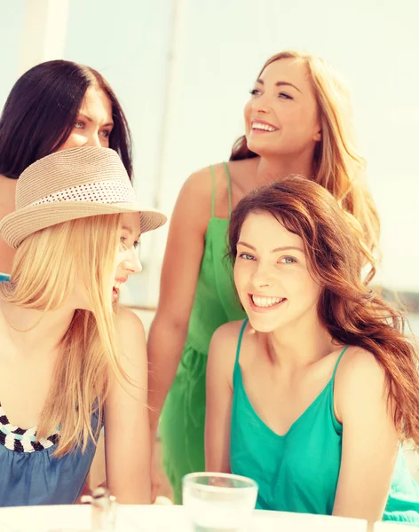 Groep van lachende meisjes in café op het strand — Stockfoto