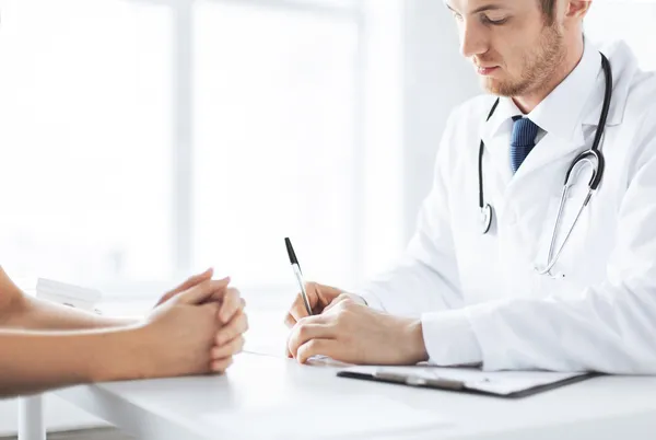 Paciente e médico tomando notas — Fotografia de Stock