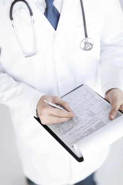 Mężczyzna lekarz trzymając w ręku recepty papieru — Zdjęcie stockowe