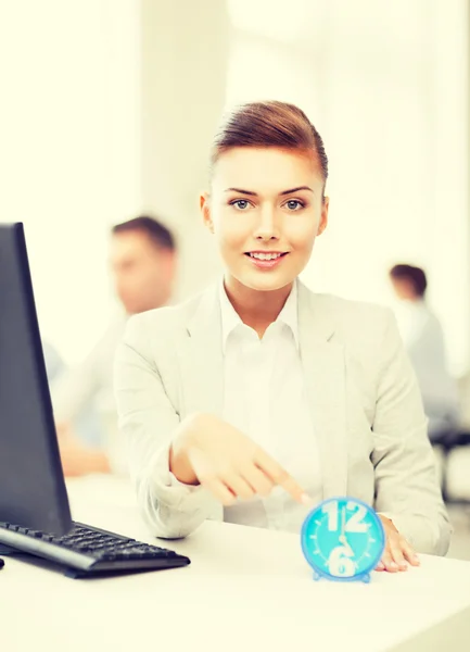 Zakenvrouw wijzend op de klok in office — Stockfoto