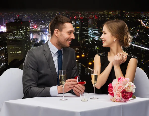Uomo che chiede alla sua ragazza di sposarsi al ristorante — Foto Stock