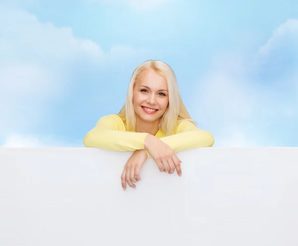Uśmiechnięta kobieta w swetrze z pustym pokładzie biały — Zdjęcie stockowe