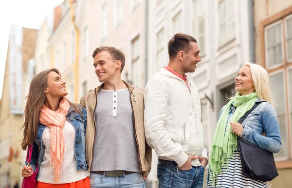 Grupp leende vänner gå i staden — Stockfoto