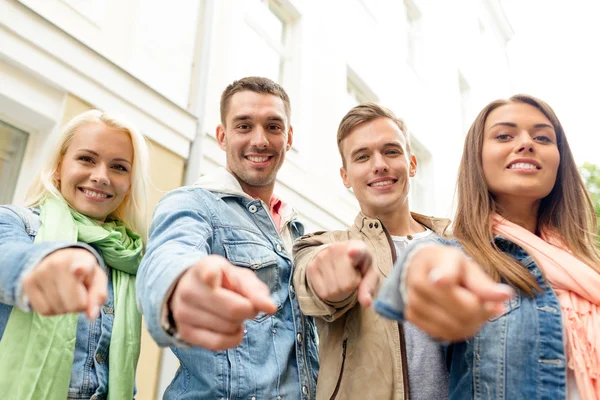 Grupo de amigos sorridentes na cidade apontando dedo — Fotografia de Stock