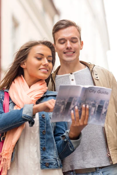 Couple souriant avec guide de la ville explorer la ville — Photo