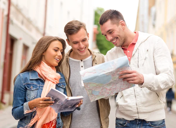 Groep lachende vrienden met city guide en kaart — Stockfoto