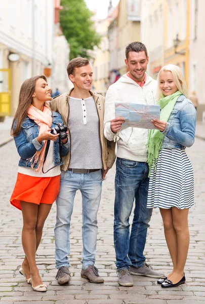 Grupo de amigos sorridentes com mapa e fotocâmera — Fotografia de Stock