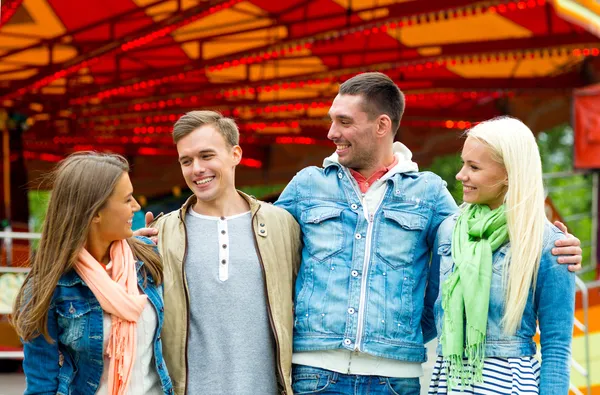 Grupo de amigos sorridentes no parque de diversões — Fotografia de Stock