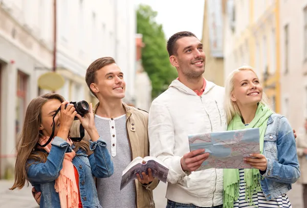 Groep vrienden met city guide, kaart en camera — Stockfoto