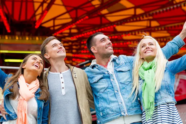 Группа улыбающихся друзей в парке развлечений — стоковое фото