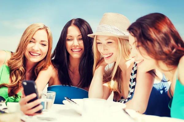Flickor söker på smartphone i café på stranden — Stockfoto
