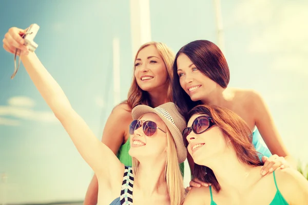 Chicas sonrientes tomando fotos en el café en la playa — Foto de Stock