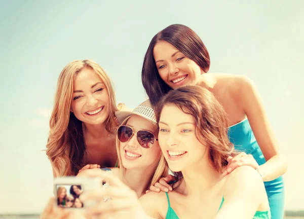 Chicas sonrientes tomando fotos en el café en la playa —  Fotos de Stock