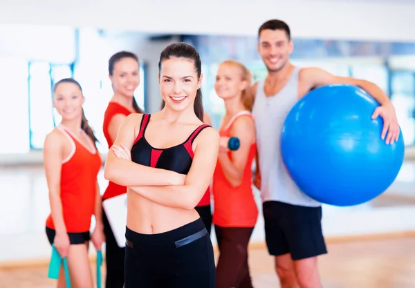 Woman standing in front of the group in gym — Stock Photo, Image