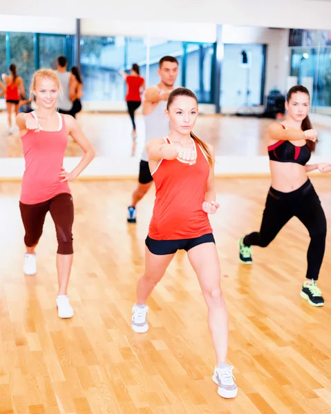 Grupo de personas concentradas haciendo ejercicio en el gimnasio —  Fotos de Stock