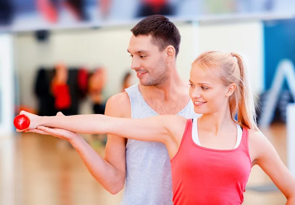 Male trainer with woman working out with dumbbell — Stock Photo, Image