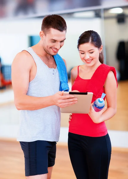 Två leende människor med TabletPC i gymmet — Stockfoto