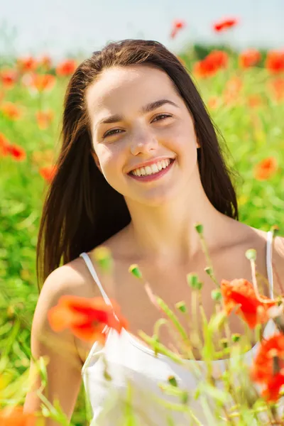 Smiling young woman on poppy field — Stock Photo, Image
