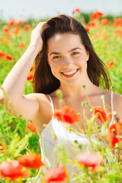 Sonriente joven mujer en amapola campo — Foto de Stock