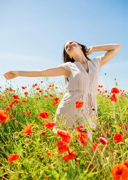 Smiling young woman on poppy field — Stock Photo, Image