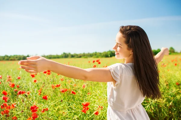 Smiling young woman on poppy field — Stock Photo, Image